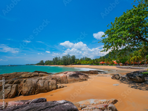 Uninhabited tropical rocky beach with blue sky photo