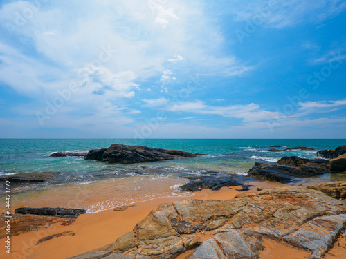 Uninhabited tropical rocky beach with blue sky photo