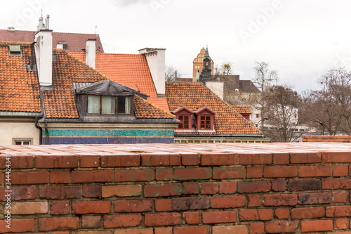 The roofs of medieval houses and the church tower in the Old Town. Lantern in the foreground. Winter season in Warsaw, Poland.