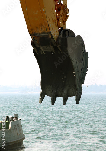 Specialized floating excavator cleans marine sediments of river bottom. Deepening of shipping fairway seaside building. Dig riverbed sediments in port water area