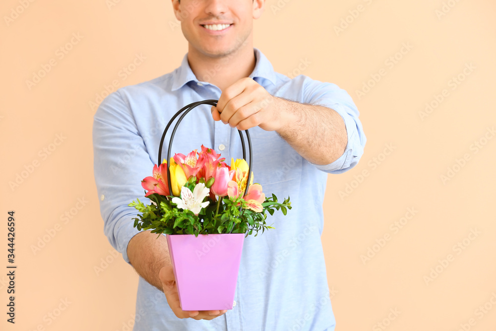 Handsome man with bouquet of flowers on color background Handsome man with bouquet of flowers on color background