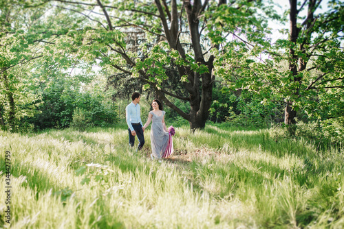 a guy and a girl walk in the spring garden of lilacs