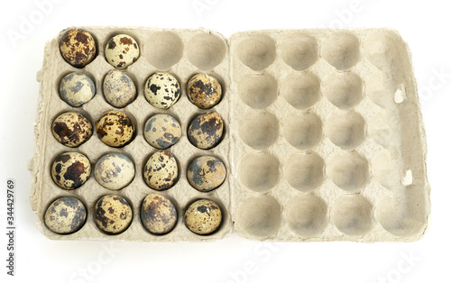 Quail eggs in a carton box. Flat lay. Isolated. White background