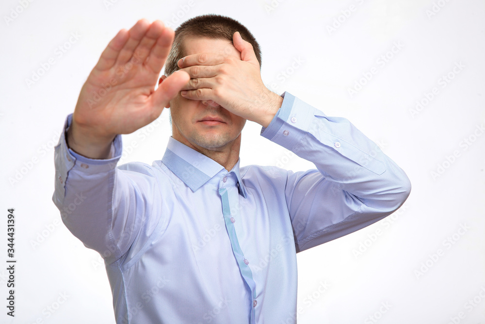 frightened cowardly man put his hands in front of him in fear of protection, in a blue light everyday shirt. Isolated frightened cowardly man put his hands in front of him in fear of protection, in a blue light everyday shirt. Isolated