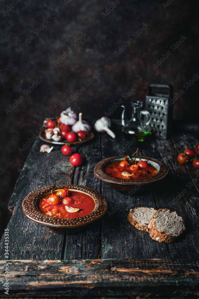 tomato soup in ceramic bowls with fresh basil leaves and bread slice on wooden background tomato soup in ceramic bowls with fresh basil leaves and bread slice on wooden background