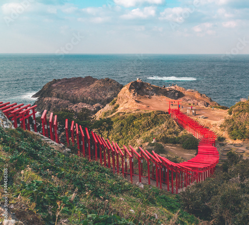 Red torii gates by the sea