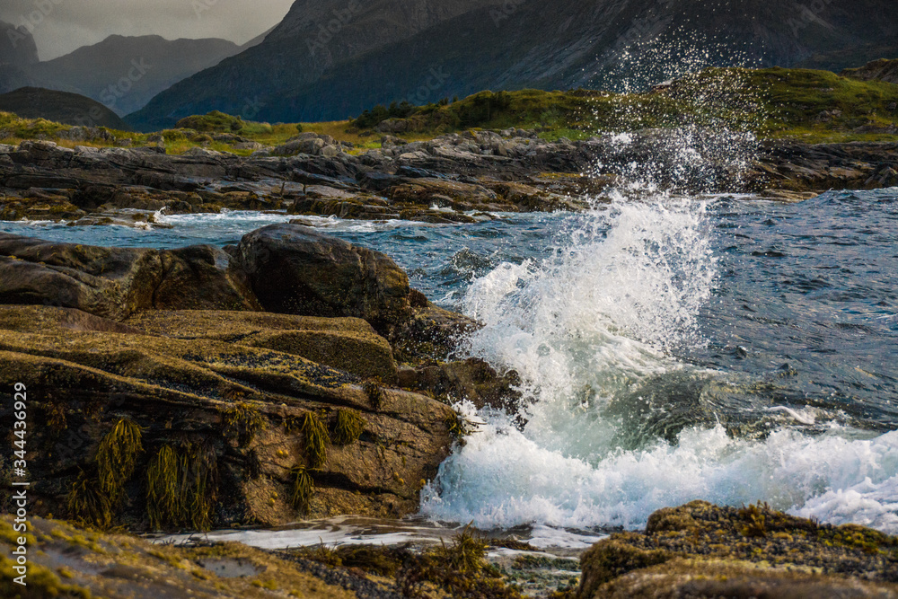 splashing waves at the coast of norway during a windy day