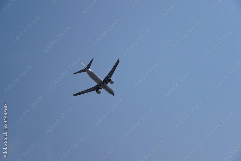 Plane flying in the sky seen from below Plane flying in the sky seen from below