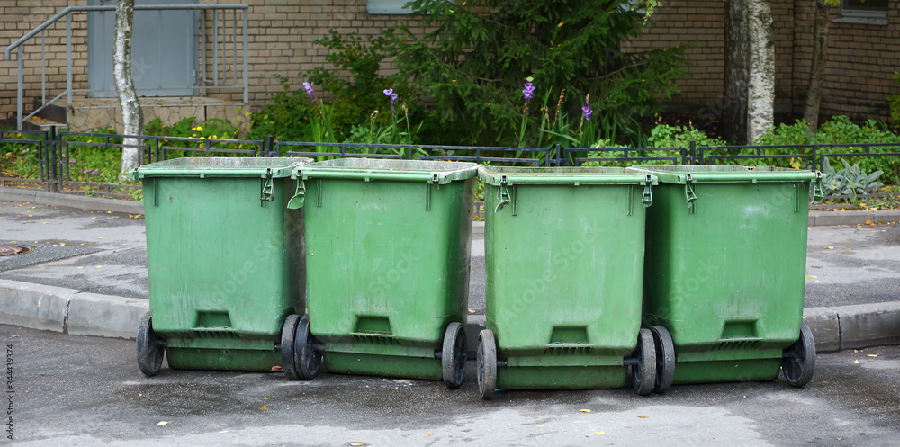 Mobile garbage containers on wheels in the yard of a house Mobile garbage containers on wheels in the yard of a house