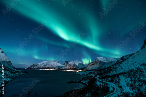 Fototapeta Naklejka Na Ścianę i Meble -  polar lights also called northern lights or aurora borealis in northern norway during winter above a fjord and snow covered mountains