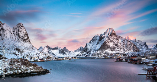 mountains and village of norway on the lofoten islands during winter while sunset and warm colors and blue sea