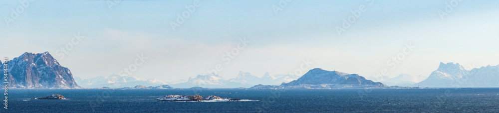 panoramic view in norway on the lofoten islands with warm colors and snow mountains