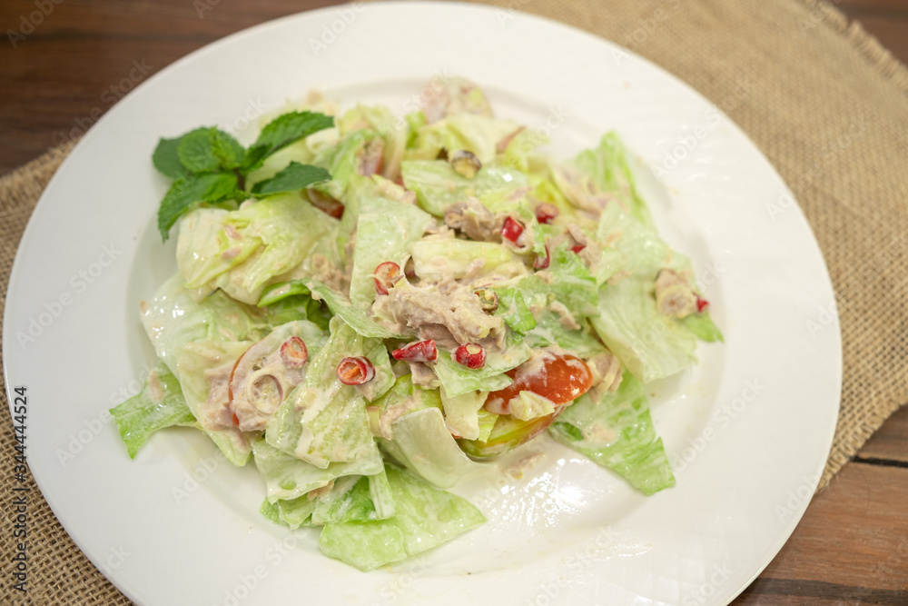 Tuna spicy salad on white plate wooden table Tuna spicy salad on white plate wooden table