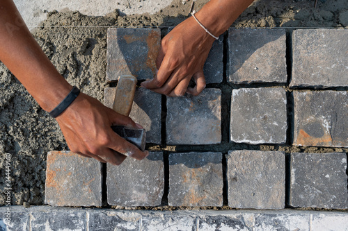 Close up hand of Masoners building masonry on the ground