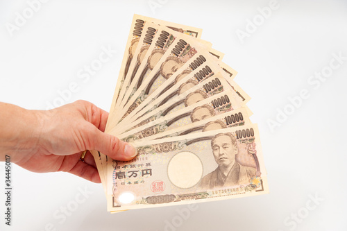 Hand holding 100,000 yen. Isolated on white background. Copy space. Horizontal shot.