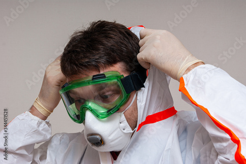 medical officer puts on a protective suit