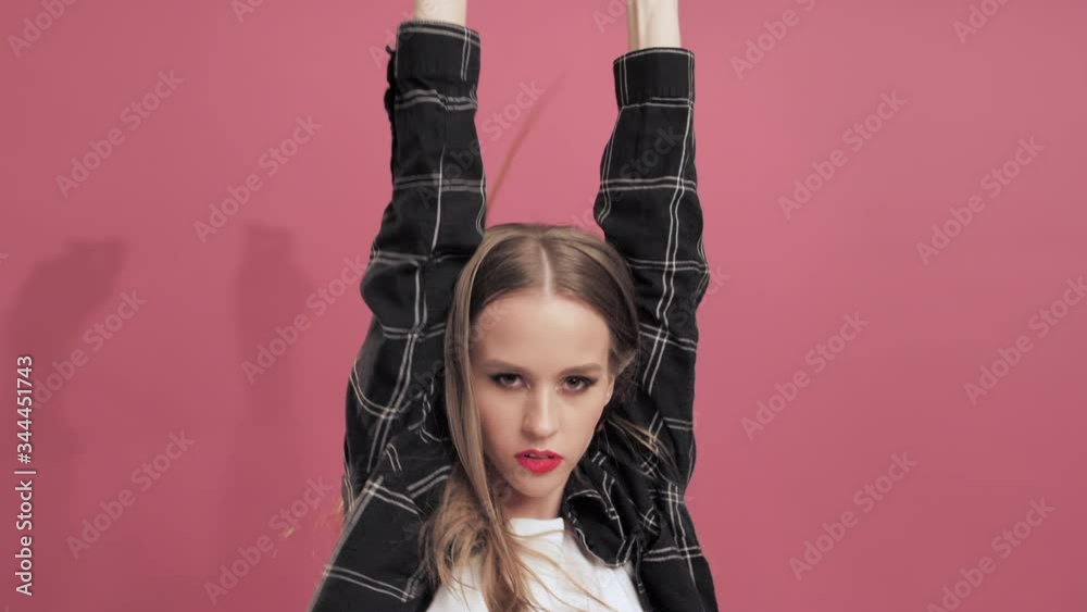Young Teenage Girl with Long Hair Dancing and Having Fun on Rose Background. Celebrating joy and happiness. Success, party, holiday concept Young woman Shaking Hair While Listening to Music Young Teenage Girl with Long Hair Dancing and Having Fun on Rose Background. Celebrating joy and happiness. Success, party, holiday concept Young woman Shaking Hair While Listening to Music