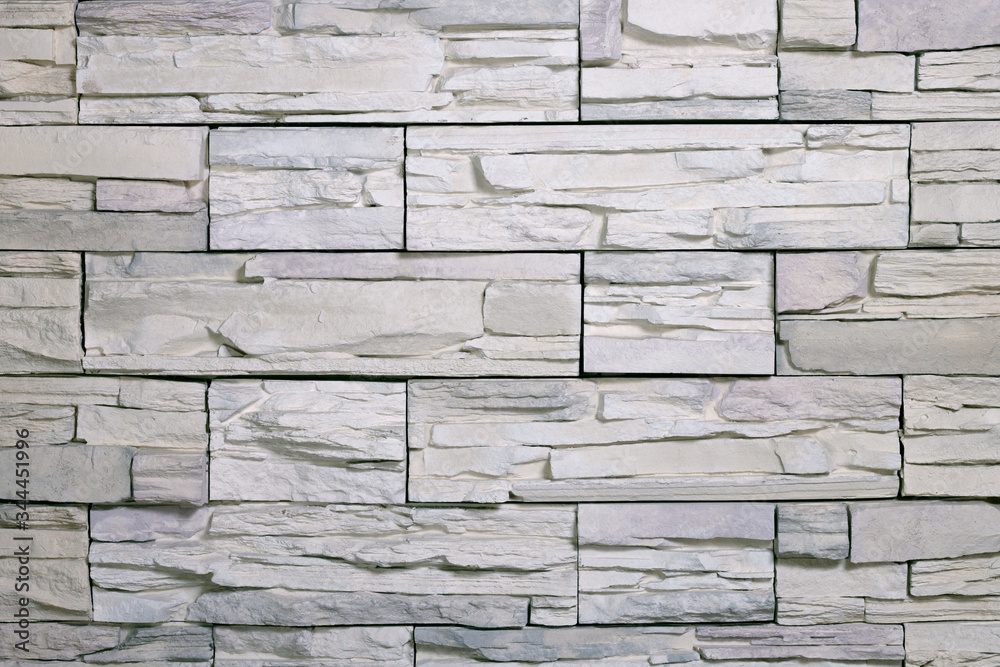 Fototapeta premium Texture of artificial white facing stone tiles. Background, material for the design.