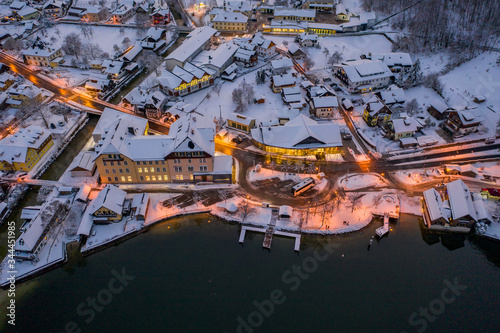 Aerial drone shot of Lahn village center by Hallstatt lake in winter after sunset in Austria © Davidzfr