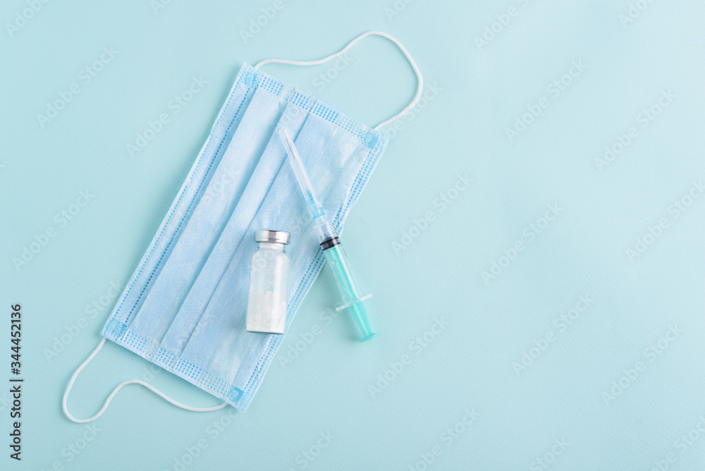 medical syringe, ampoule, medical mask on blue background, vaccination, inoculation concept, copy space medical syringe, ampoule, medical mask on blue background, vaccination, inoculation concept, copy space
