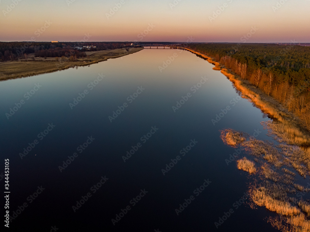 Fototapeta premium River Lielupe Coutnryside view in sunset near shoreline with beautiful pine tree forest.