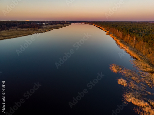 River Lielupe Coutnryside view in sunset near shoreline with beautiful pine tree forest.