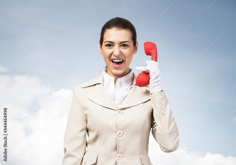 Expressive woman holds handset phone on distance Expressive woman holds handset phone on distance
