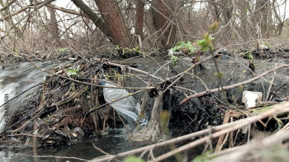 ecological catastrophy. spring clean creek contaminated with plastic garbage bottles. 4k ecological catastrophy. spring clean creek contaminated with plastic garbage bottles. 4k