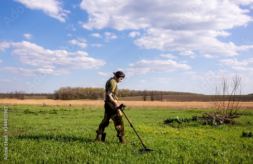 A man is looking for a treasure with a metal detector photo