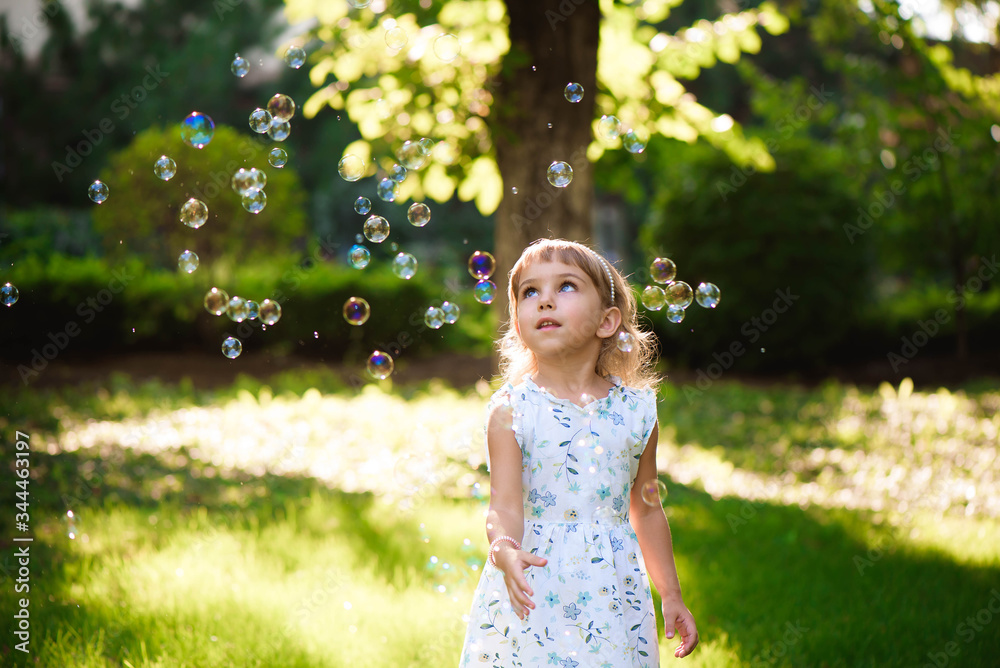 Happy baby girl standing in grass with dandelions Happy baby girl standing in grass with dandelions