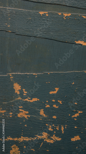 Background of old peeling blue paint wooden board with cracks