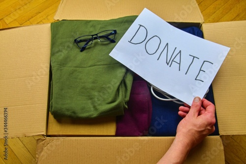 Donation concepts with hands of man holding text DONATE . Giving and sharing things with other people.