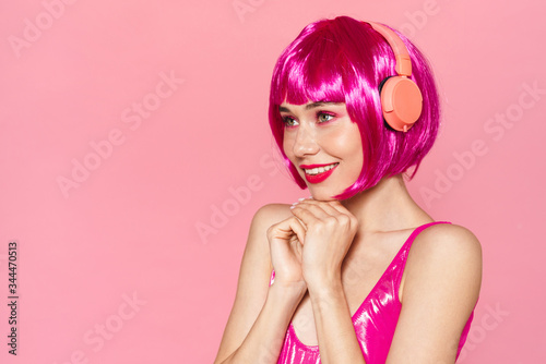 Image of joyful pretty woman smiling and using wireless headphones © Drobot Dean