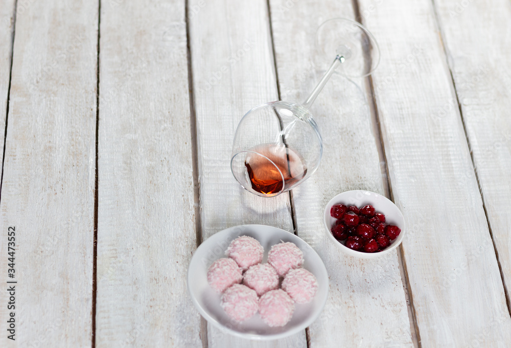 Raspberry energy balls with fresh berries, rose wine in laying glass on white rustic wooden background Raspberry energy balls with fresh berries, rose wine in laying glass on white rustic wooden background