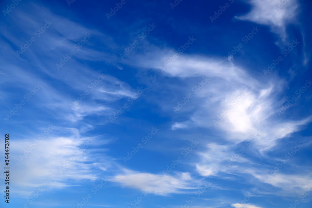 Blue sky landscape background. Picturesque beautiful cirrus clouds create unusual patterns in the sky. Cloudy weather in spring and summer.