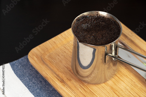 Brewed coffee in a metal turk on a kitchen counter close up photo