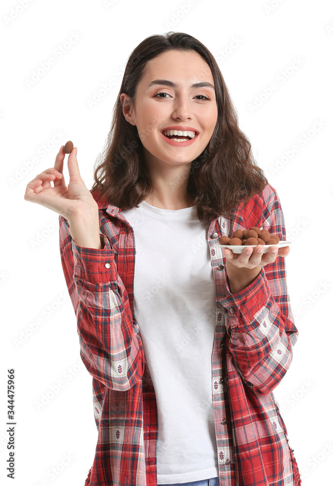 Beautiful young woman eating tasty chocolate candies on white background Beautiful young woman eating tasty chocolate candies on white background