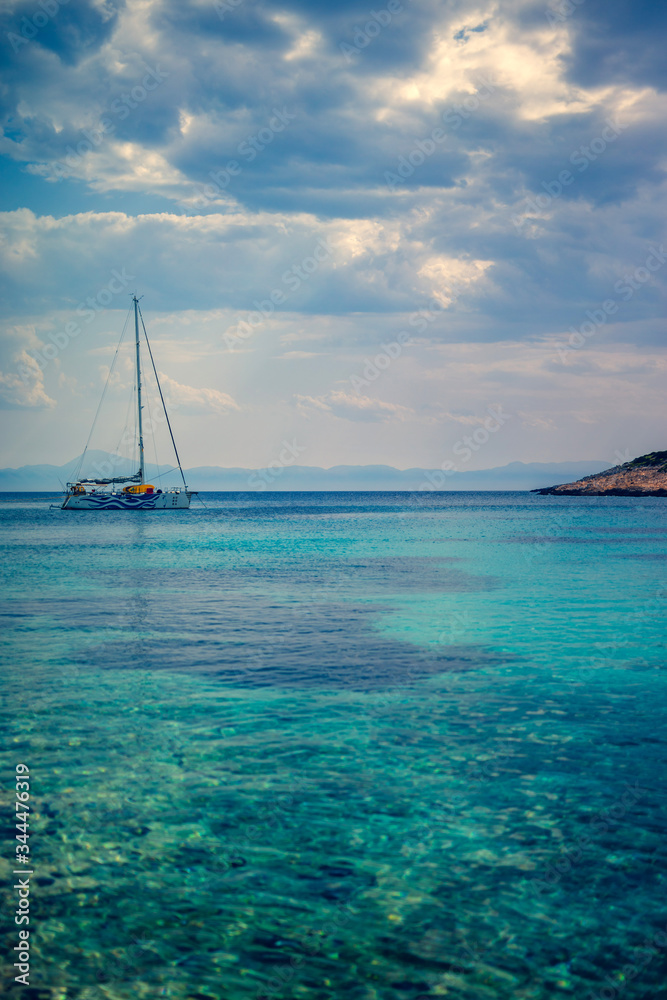 Sailing boat at distant remote island paradise with exotical vivid colors.