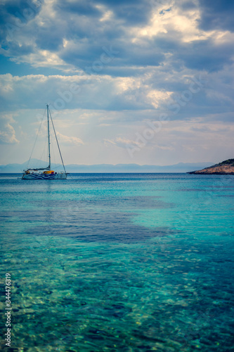 Sailing boat at distant remote island paradise with exotical vivid colors.