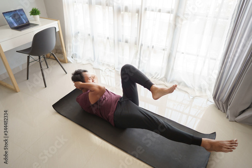 asian man sitting up workout from home in the morning