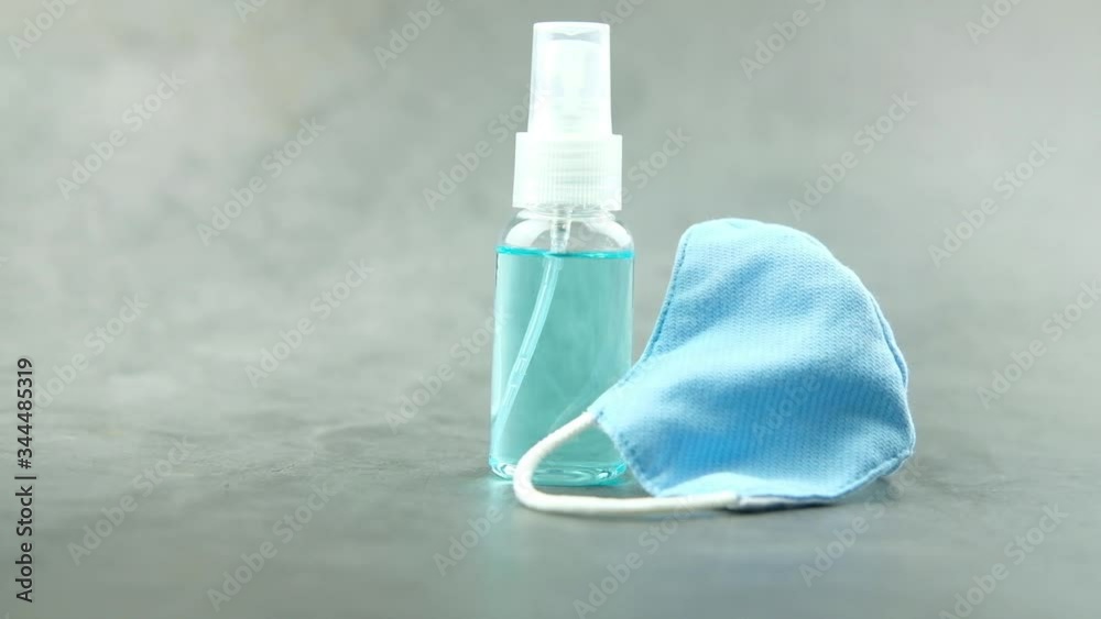 Spray and blue mask on a black background for means of protection against disease Spray and blue mask on a black background for means of protection against disease