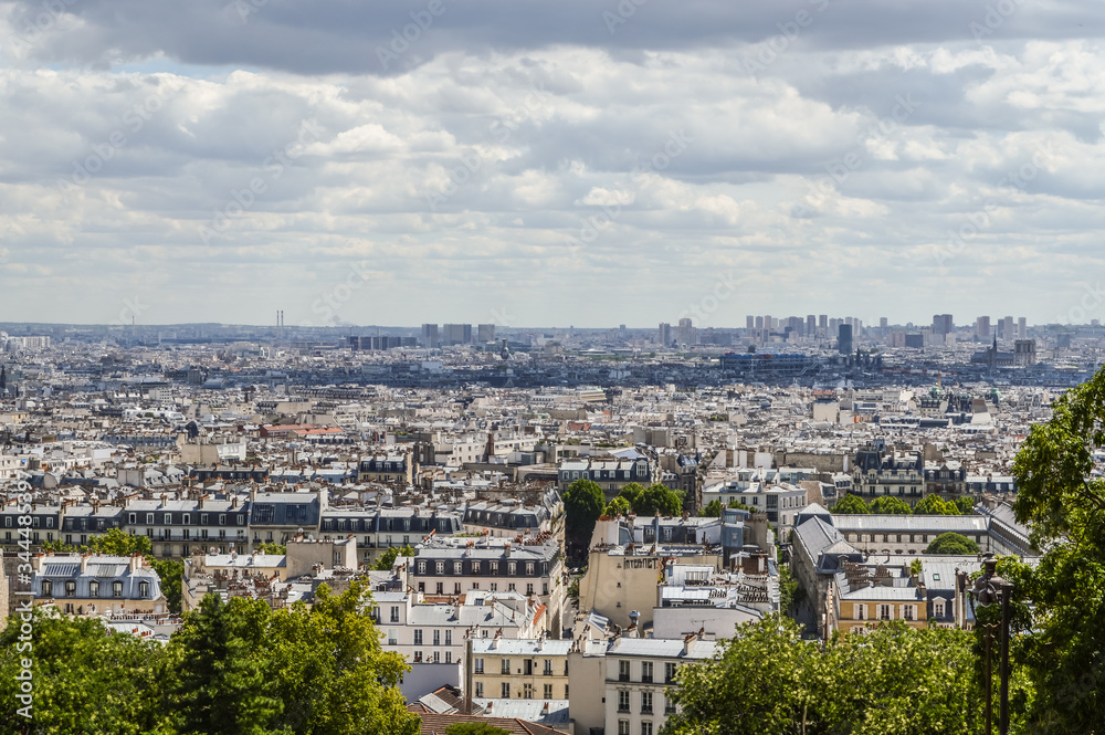 Paris skyline, view from the Sacre Coeur on Montmartre hill, France. Basilica of Sacre Coeur is one of the landmarks in Paris. Aerial view of Paris in summer. Panorama of Paris city on a cloudy day.