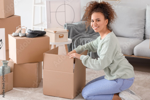 Young woman unpacking moving boxes in her new home © Pixel-Shot