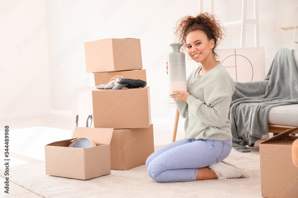 Young woman unpacking moving boxes in her new home Young woman unpacking moving boxes in her new home