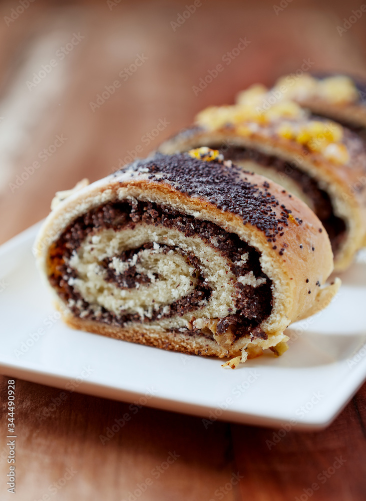 Poppy seed roll on wooden background. Close up. Poppy seed roll on wooden background. Close up.