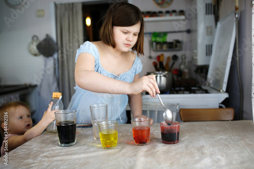 Child girl experiments with mixing colors at home