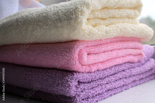 Terry towels pink, lilac, yellow folded. © Kartashova
