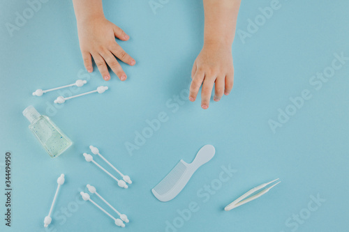 Baby play with toiletries, toys and health care accessories on blue background. © Iryna