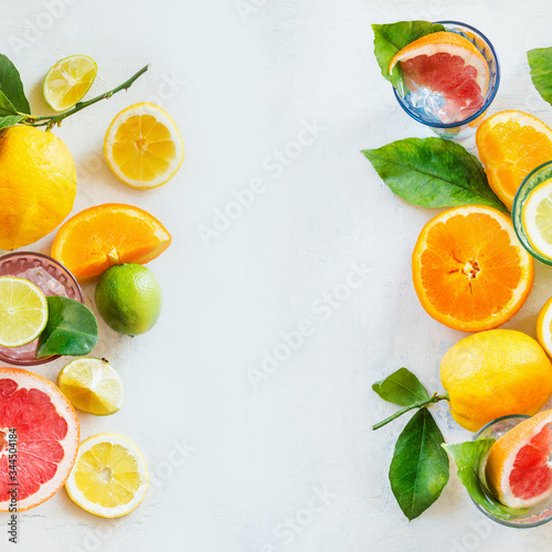 Bild auf Leinwand Frame of various citrus fruits with green leaves on white table, top view