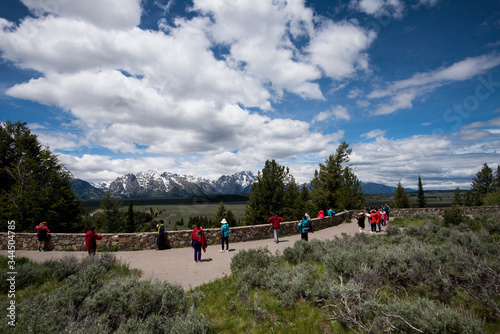 Grand Teton national Park at the Snake River overlook viewing point, with tourists wearing colorful clothes and taking photographs